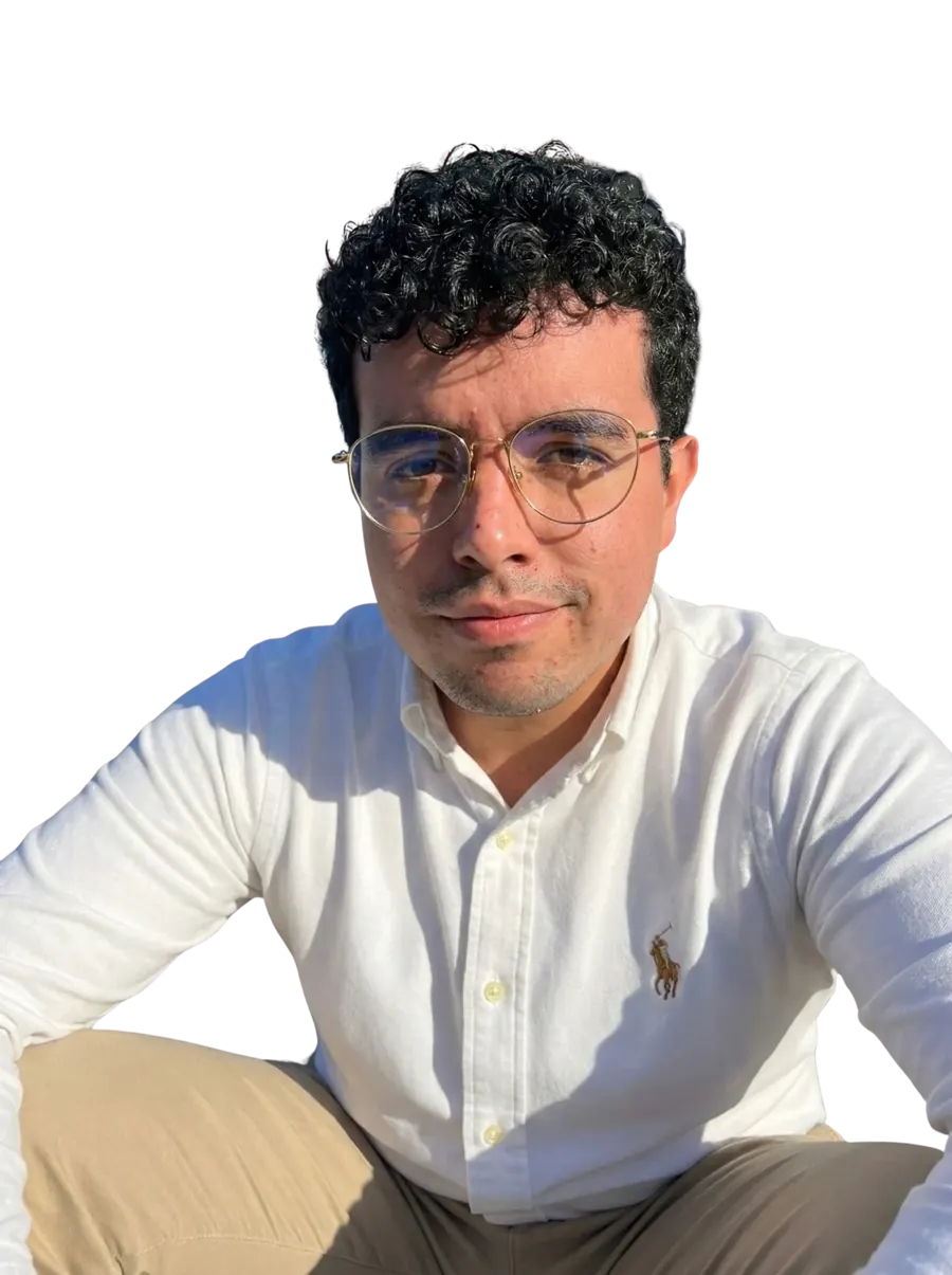 Guillermo Rogel sentado al sol, con camisa blanca y lentes de marco dorado